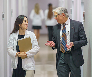 Medical Professionals talking to each other as they walk down a hallway. Links to Ages 45–65